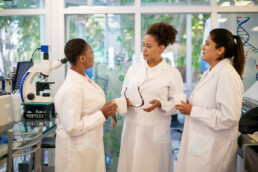 Scientists wearing lab coats discussing at laboratory