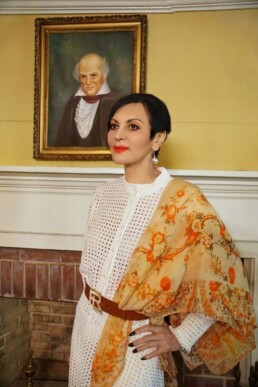 Regina Lynch-Hudson stands in front of a portrait of her fifth-great grandfather, Colonel John Carson